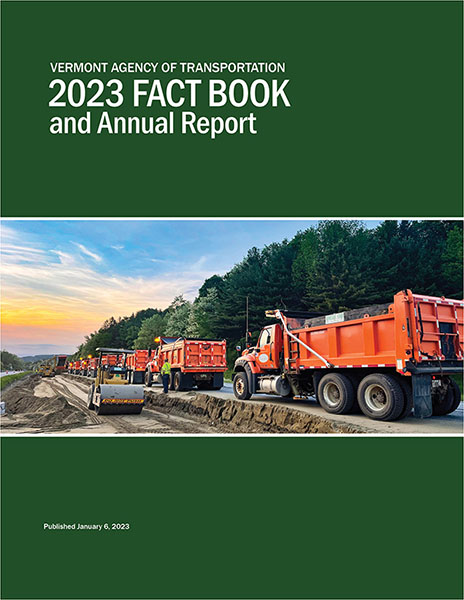 Cover of the 2023 AOT Fact Book and Annual Report, featuring a row of AOT dump trucks next to a construction site on I-89 in Richmond, VT.