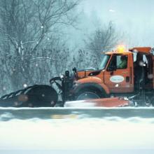 Snow Plow Truck Plowing a Snowy Road