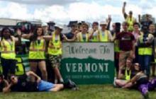 Kids with sign that says "Welcome to Vermont'