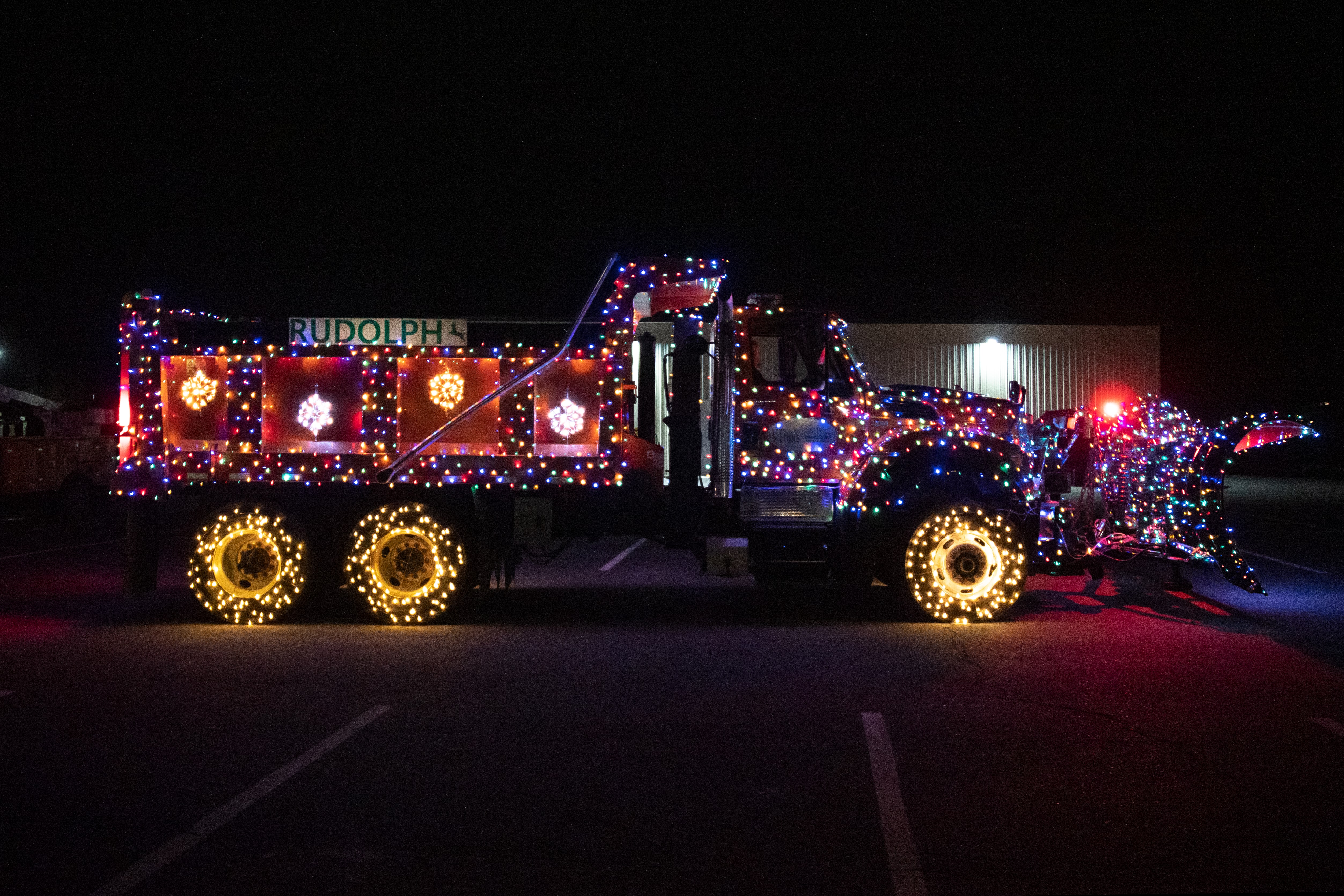 An AOT Plowtruck adorned with Christmas lights, bright shiny red "nose," and a sign that reads "Rudolph."