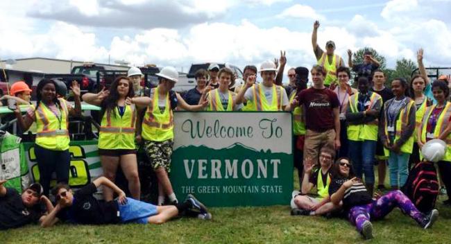 Teenagers with sign "Welcome to Vermont"